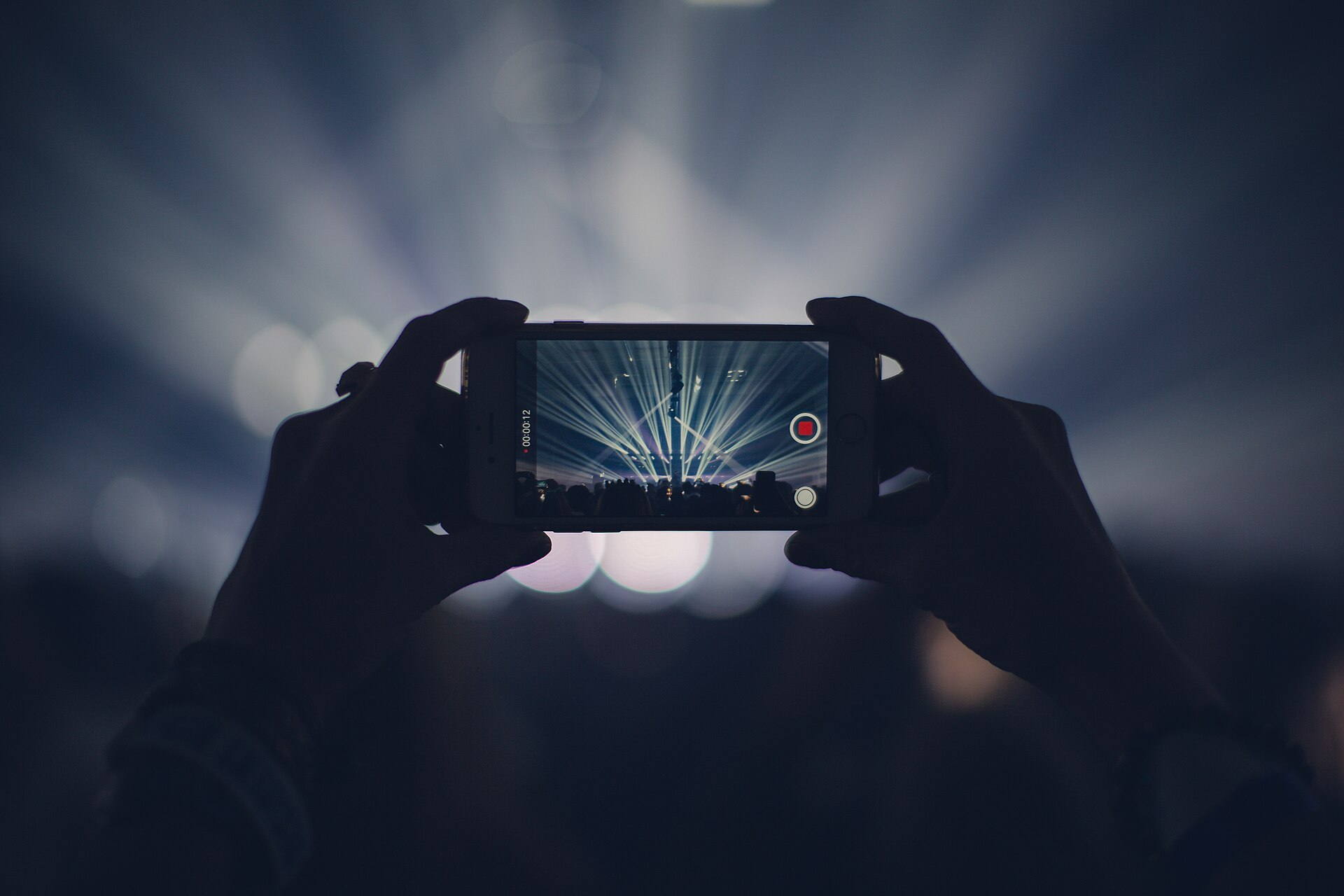 A concertgoer recording a live performance on a phone